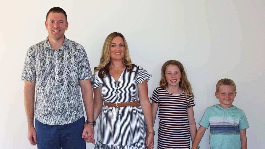 Simon and Tanya Vulinovic and their two children stand in a line.