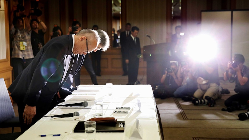 Officials from Tokyo Medical University apologise, bowing.