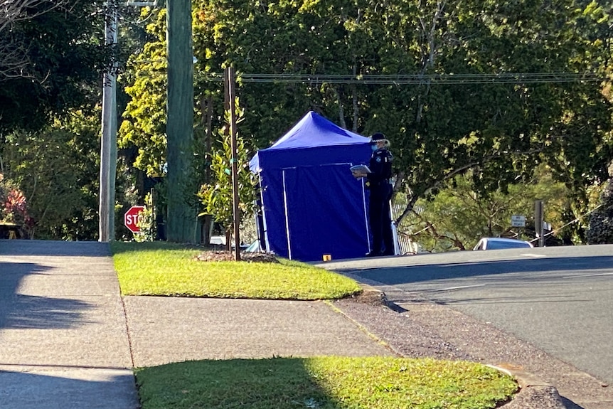A police tent erected on a street where a man was found with critical injuries.