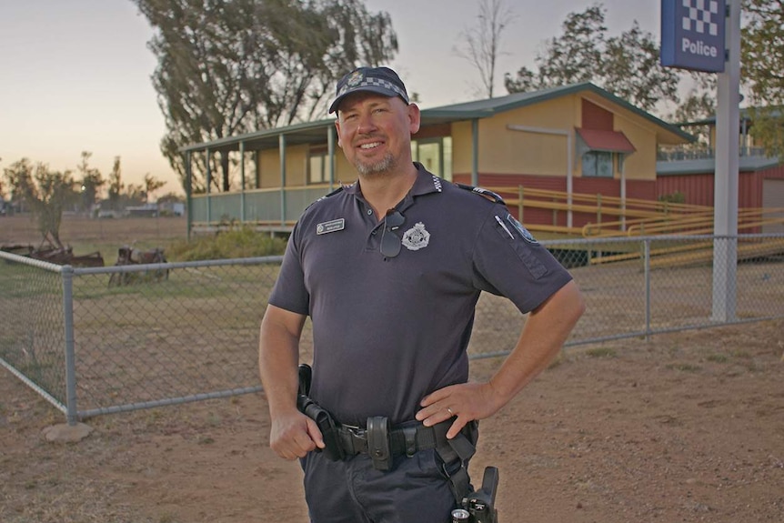 A police officer stands in front of a Police Station