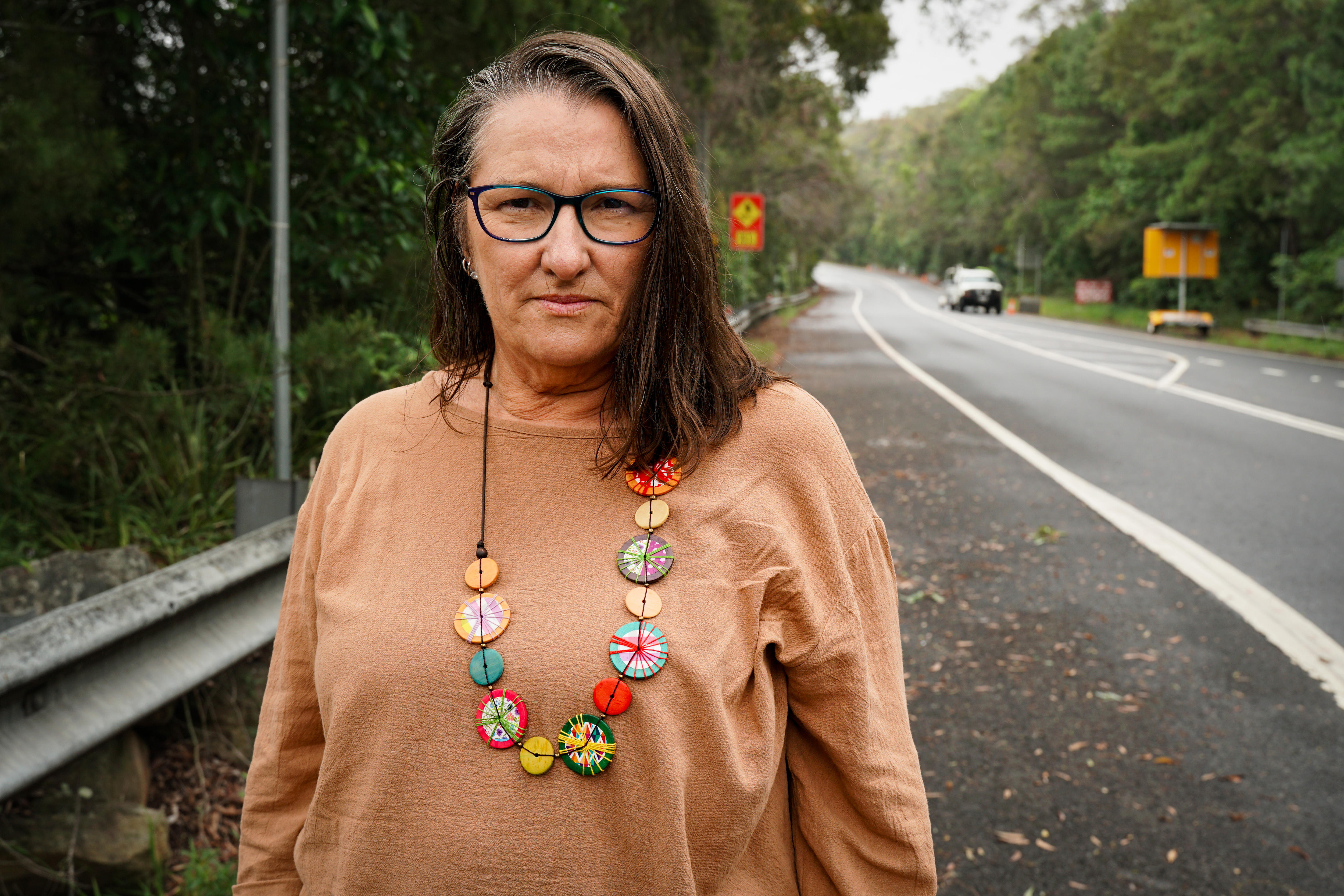 A woman standing on the side of a road.