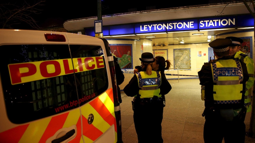 Police officers investigate the crime scene in London.