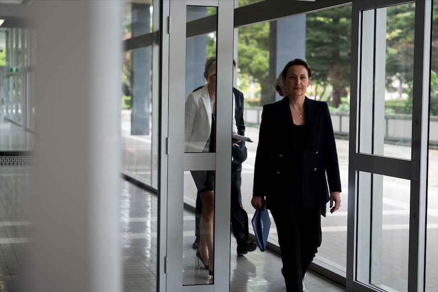a woman in a suit walking into a building