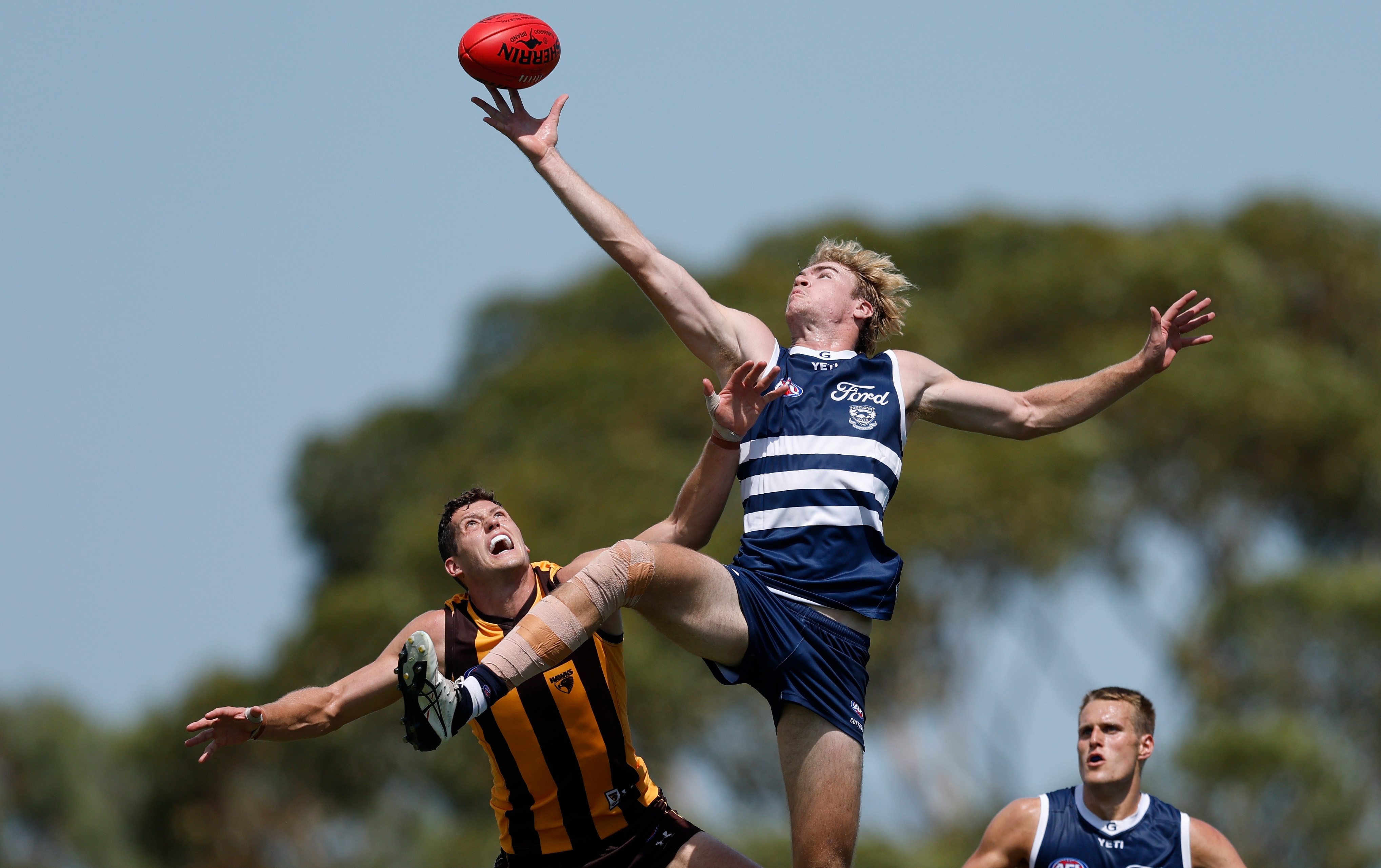Mitch Edwards leaps above Lloyd Meek to tap the ball in a ruck contest