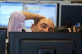 A bond trader partially obscured by his monitor