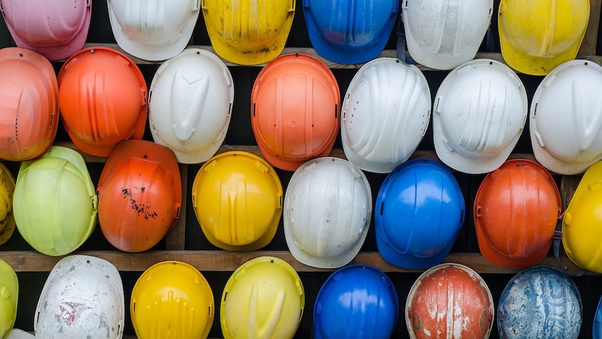 Hard hats hang on a wall