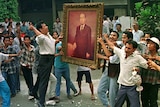 Rioting mobs take out their anger on the portrait of Indonesia's wealthiest man Sudono Salim.