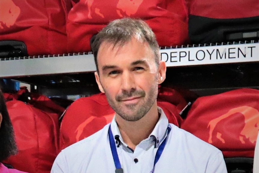 Cropped headshot of man from a group photo in a shed.