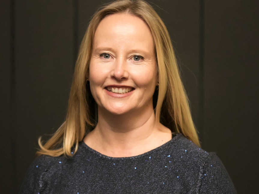 A woman with blonde hair smiles for the camera 