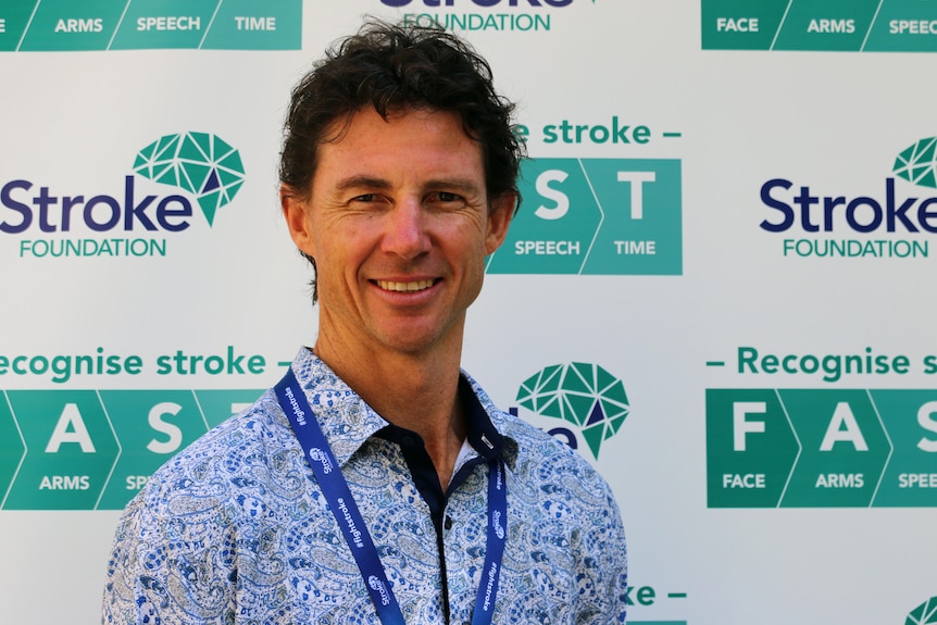 A man in front of Stroke Foundation signage.