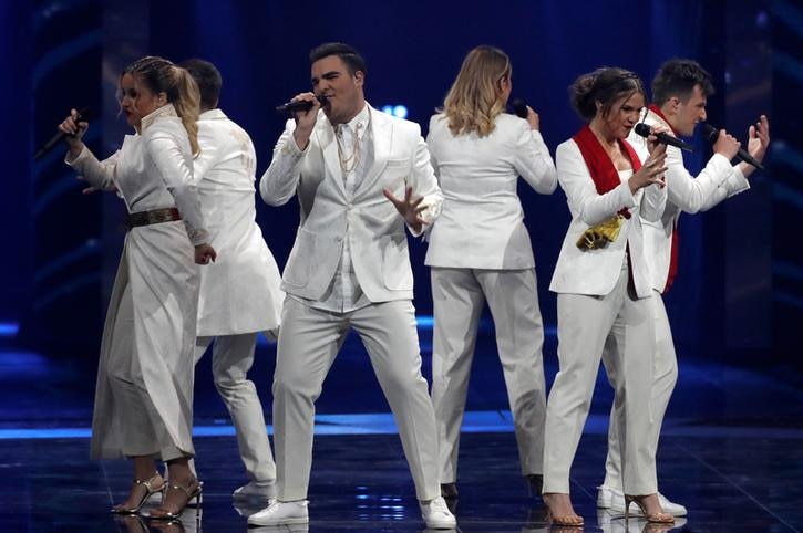 D-Moll, a group of six, wear all white as they sing arranged in a circle.