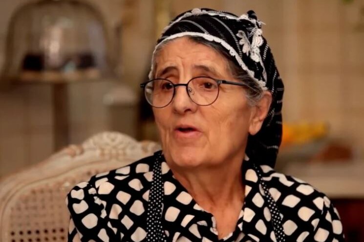 An elderly woman wearing a headscarf.
