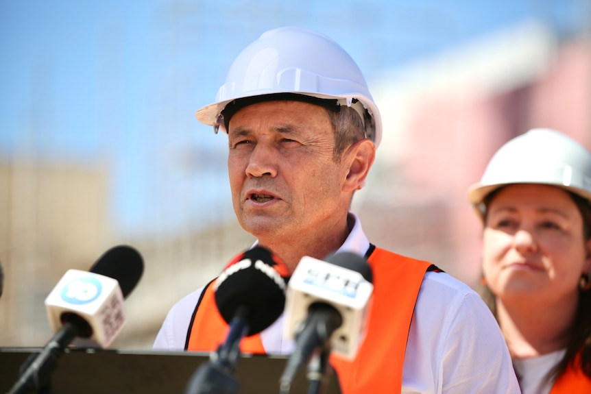 Man in hardhat speaks at press conference
