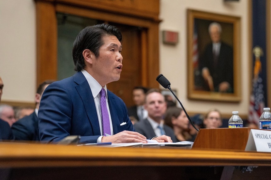 Special Counsel Robert Hur testifies. An asian man in a purple tie speaks into a mic 