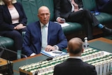 dutton looks across the main table in parliament at albanese, whose head is in the foreground