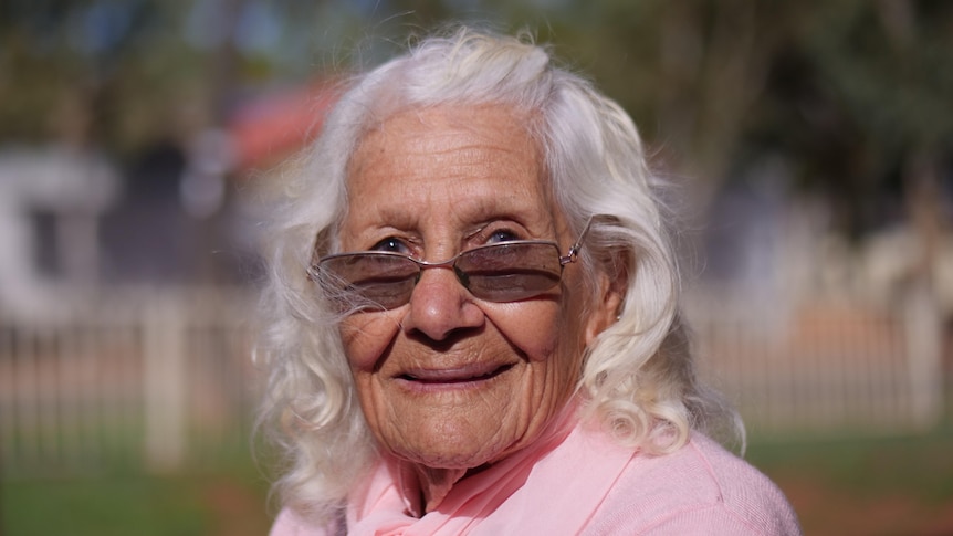 An old Aboriginal woman with sunglasses and white hair. 