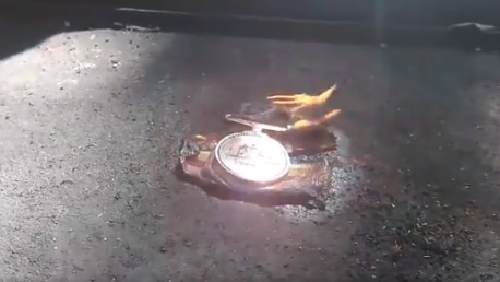 A video still of a military medal on fire