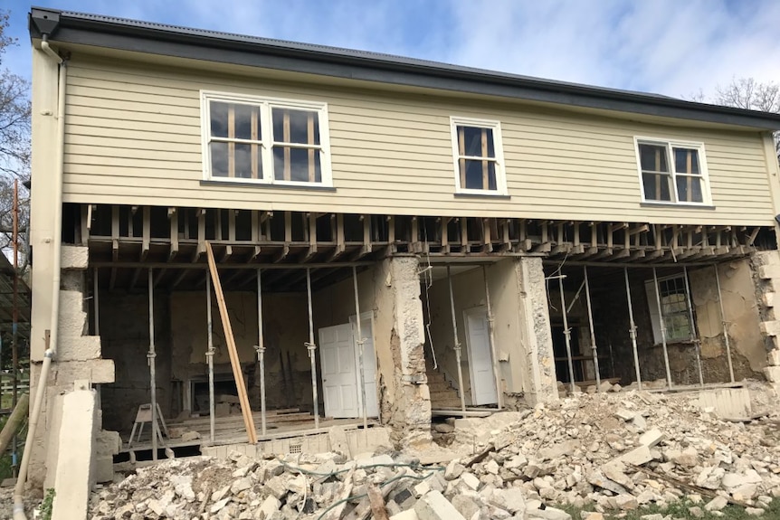 The Glover house with the back wall removed and rubble around it.