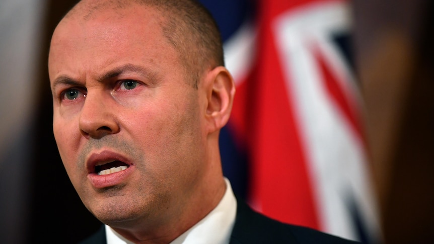 A close up of a man speaking at a lectern 