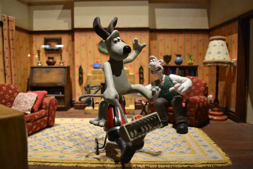 Gromit from Wallace and Gromit riding a vacuum cleaner.