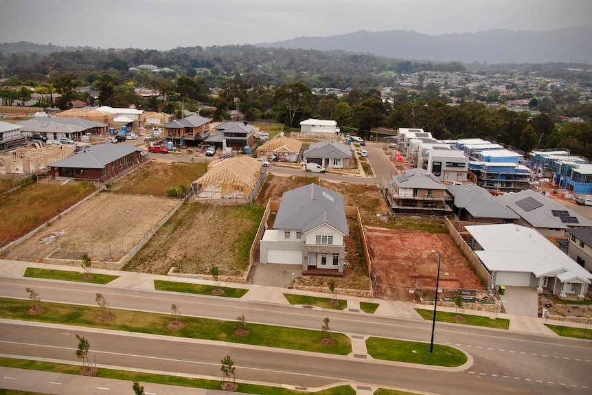 An aerial photo of a new housing estate with empty blocks and several new houses being built.