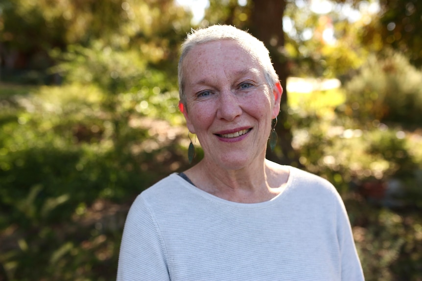 Angela Cooney in an outdoor setting wearing a light coloured jumper while smiling