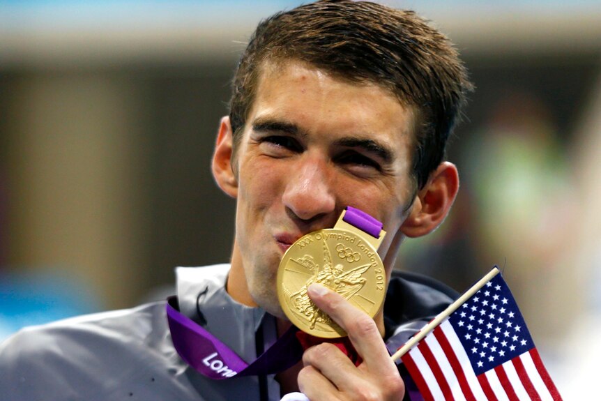 Michael Phelps of the US kisses his 19th Olympic medal, won in the men's 4x200m freestyle relay.