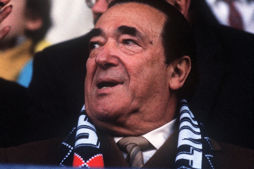 A close up of Robert Maxwell wearing a Derby County scarf.