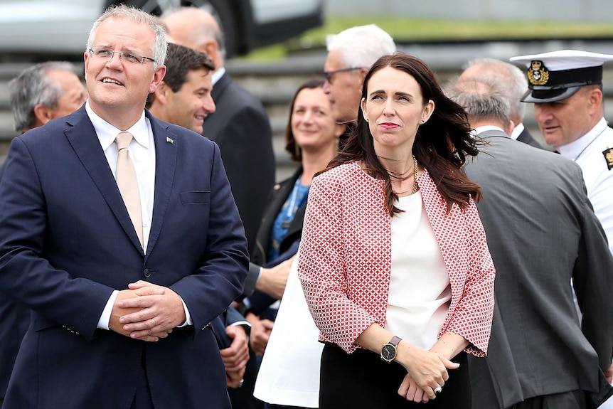 Scott Morrison stands next to Jacinda Adern. They are both looking up and to their right.