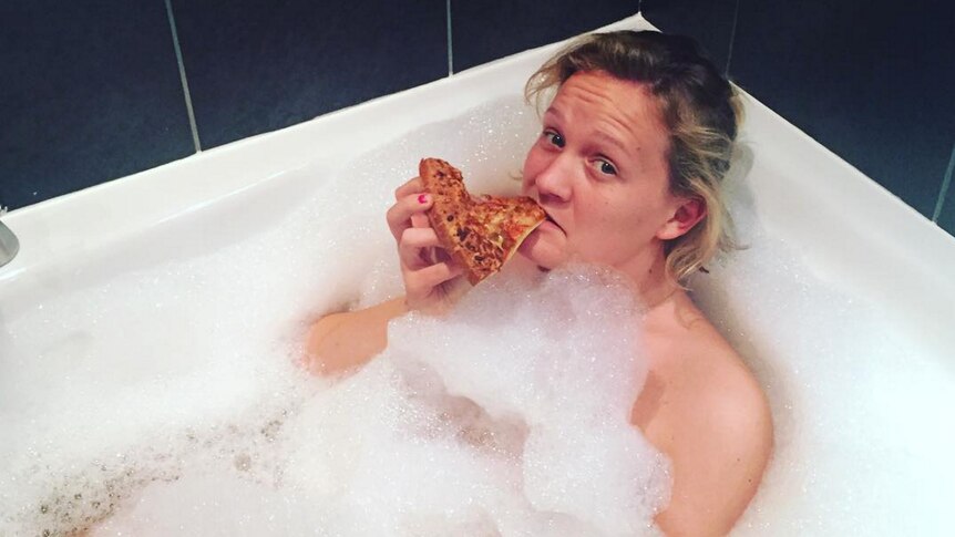 Arabella Younger eats pizza in the bath.