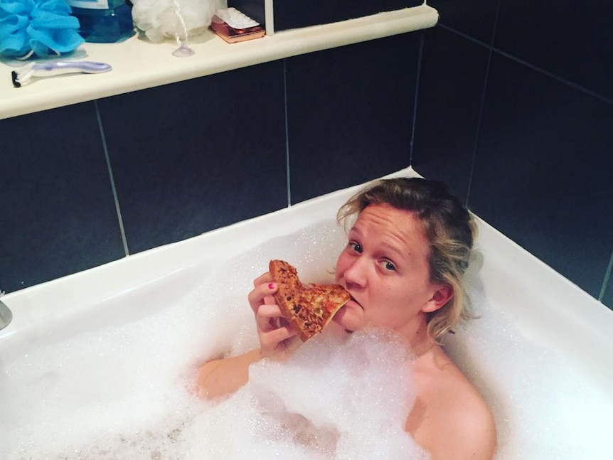 Arabella Younger eats pizza in the bath.