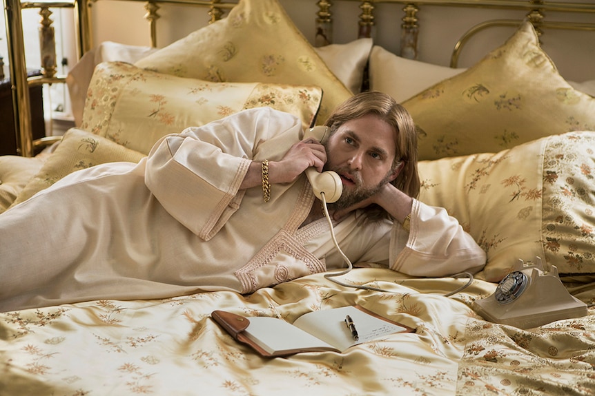 Colour still of Jonah Hill lying on in a bed and on the phone in 2018 film Don't Worry, He Won't Get Far on Foot.