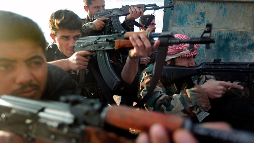 Soldiers of the Free Syrian Army, formed by army deserters, take position in an undisclosed location in Syria