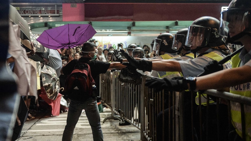 A pro-democracy protester pleads with police not to use force