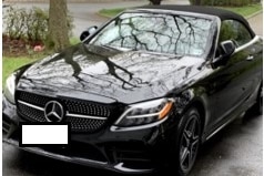 A black Mercedes convertible parked in a driveway