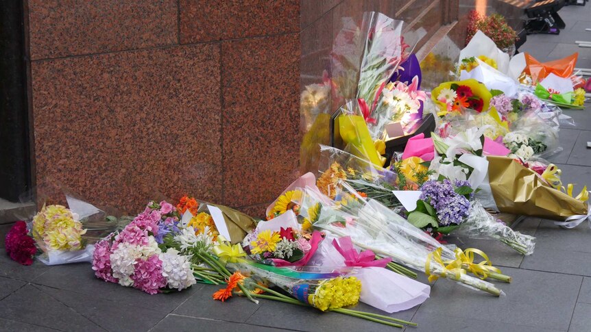 A pile of flowers lies outside the Lindt Cafe on the anniversary of the Sydney siege.