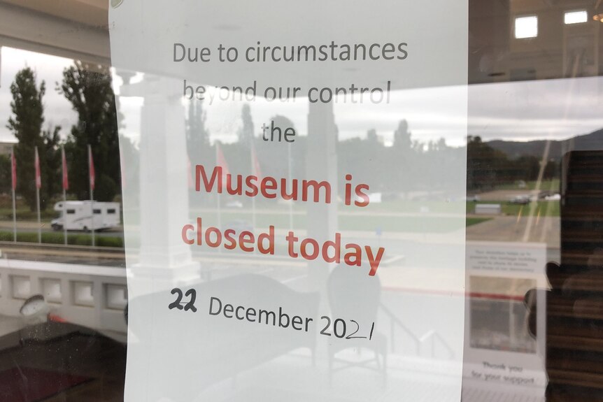 A sign up in a window reading 'due to circumstances beyond our control the museum is closed today' 