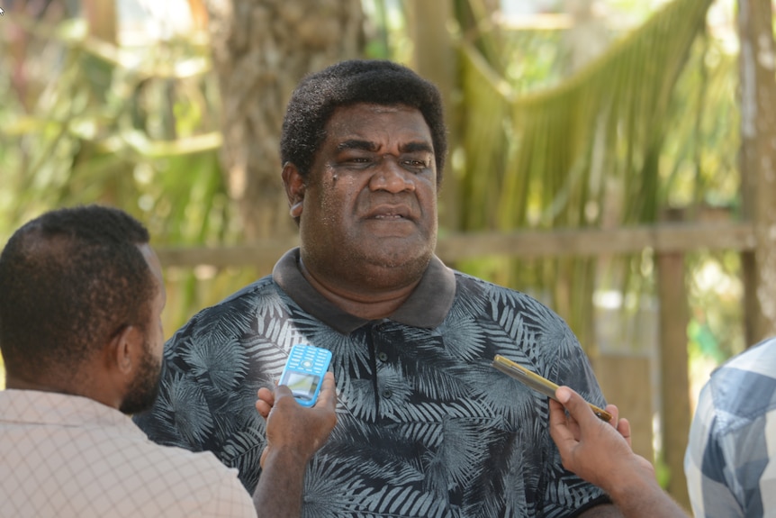 Godfrey Teamana, a recruiter in the Solomon Islands, being interviewed by journalists.