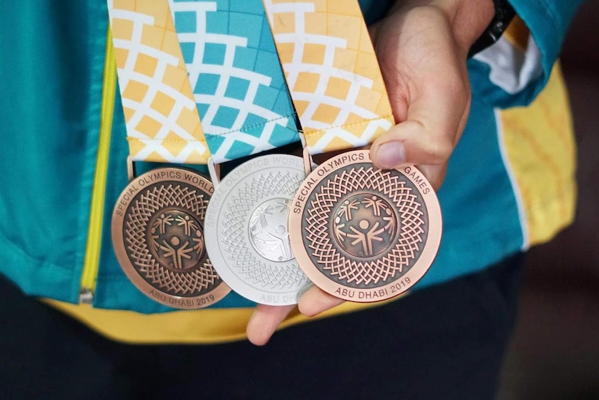 A close-up shot of two bronze medals and one silver medal with the words inscribed: Special Olympics World Games Abu Dhabi 2019.
