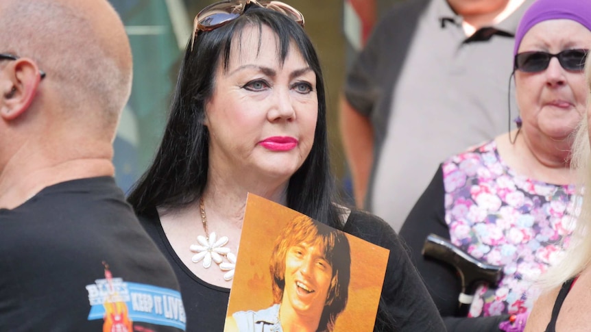 A woman holds a picture of Stevie Wright taken when the group was in its heyday.