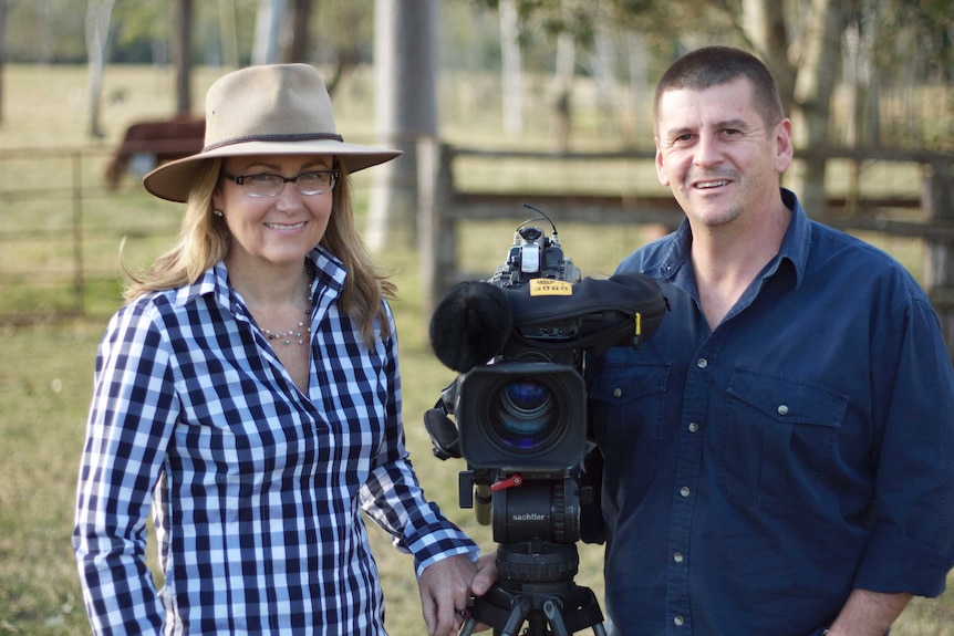 Pip Courtney wearing akubra standing next to husband John Bean and his video camera.