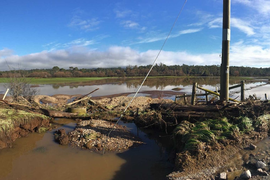 A wide image of paddocks flooded and debris throughout.