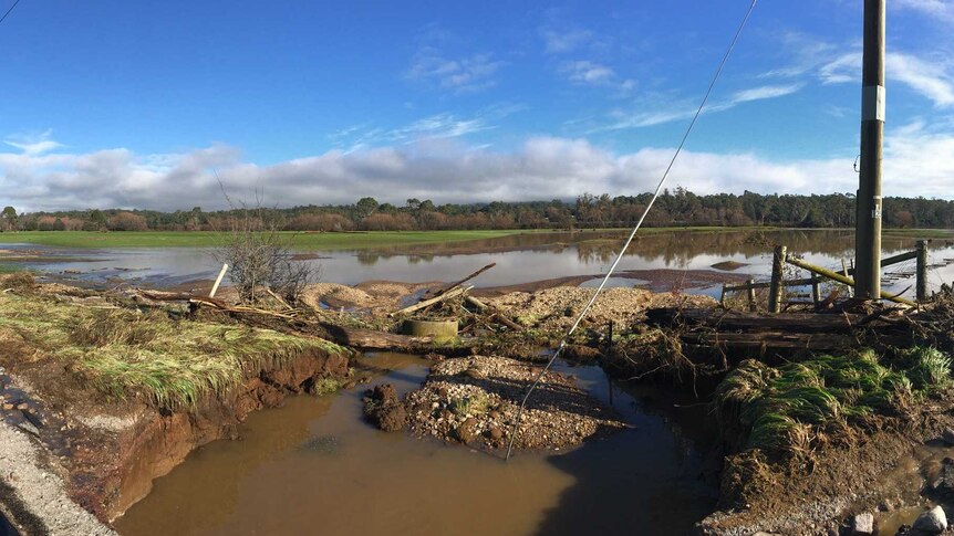 A wide image of paddocks flooded and debris throughout.