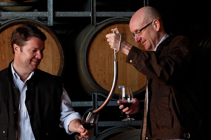 Mitch Taylor and a colleague test wine from a barrel