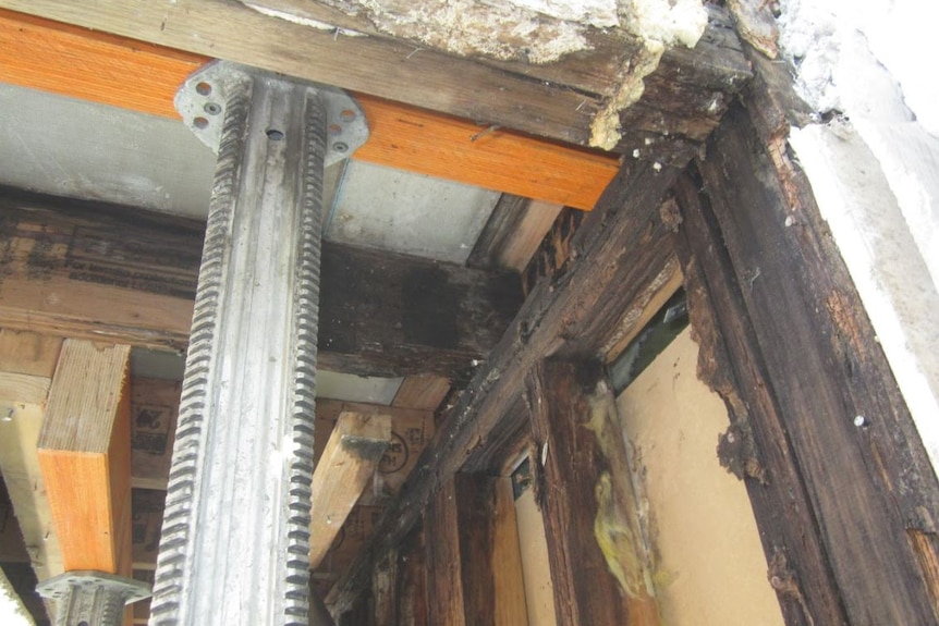 Rotting frame work. Steel beam holding up roof.