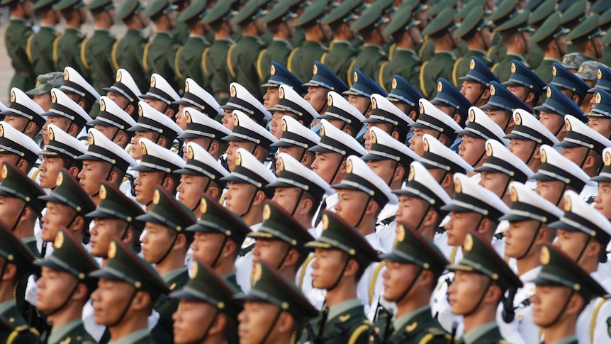 Soldiers of People's Liberation army standing in line holding riffles wearing white, blue and green uniforms