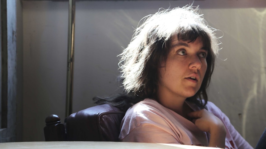 Musician Courtney Barnett, seated, with light shining from above
