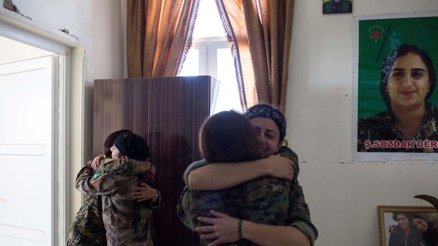 YPJ Kurdish members greet each other at a base in Ein Eissa city