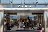 Shoppers mill around the automatic glass doors of the Zara store's imposing chrome and glass exterior.