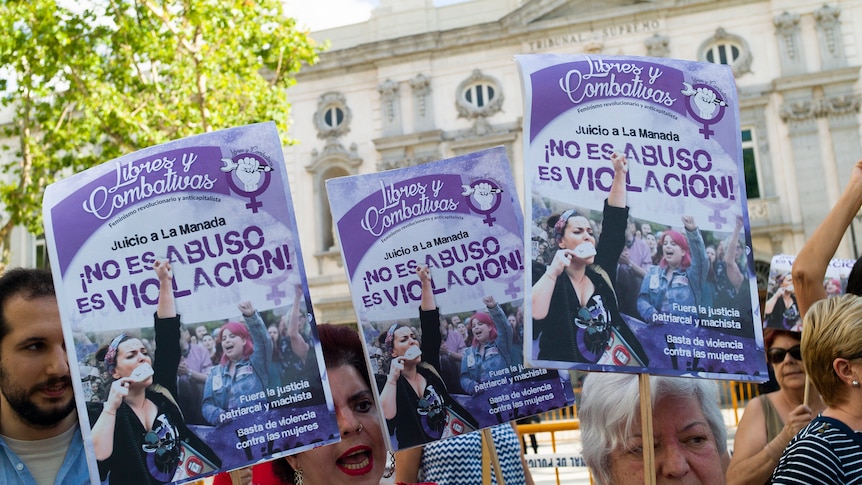 Demonstrators hold purple and white signs advocating for strong sentencing